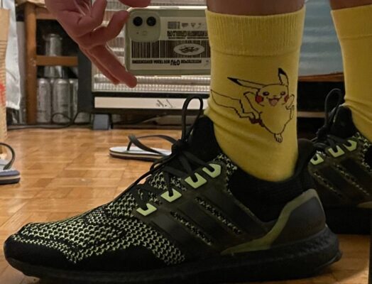 A leg with sneakers and a yeloow sock with Pikachu